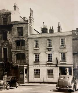 St John’s College have retained the freehold of the Lamb and Flag since 1573. Hidden away in the college archives was an unpublished picture of the Lamb in 1959. The pub was then tied to the Northampton Brewery Company (NBC), as advertised in the six-point star insignia on the St Giles’ front. 

It feels like fate to have found this commemorative jug, produced for the NBC in the coronation year. The jug would have been for sale in the pub. And now it has come home again!

Photograph reproduced with kind permission of St John’s College.